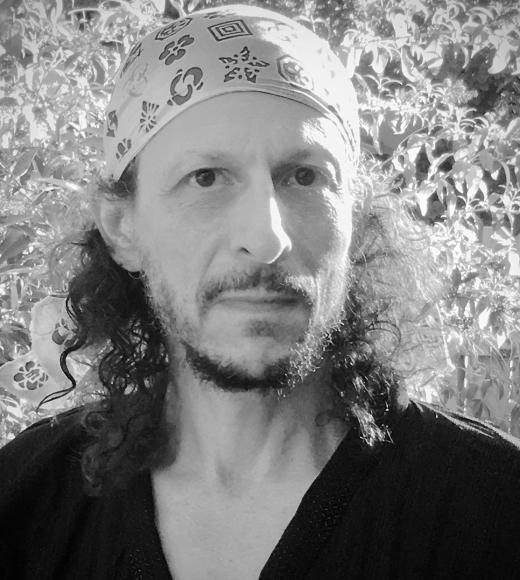 A black and white photo of a man in a bandana