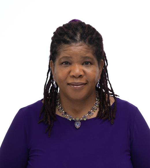 A portrait of a woman with black hair wearing a purple top