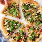 vegan pizza with hand grabbing a slice