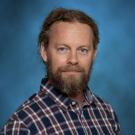 a photo of a man with a beard wearing a plaid shirt