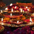 Many colorful lit candles and flowers.