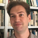 a profile of a man in front of books
