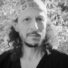 A black and white photo of a man in a bandana