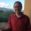 Man in red shirt in front of mountain range